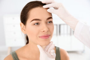 Doctor examining a woman's face after Mohs surgery in Leesburg, FL
