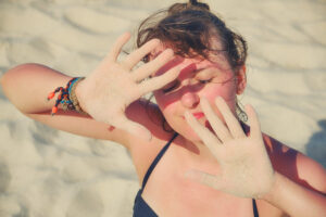 Woman shielding her face from the sun to prevent Actinic Keratosis in Leesburg, FL