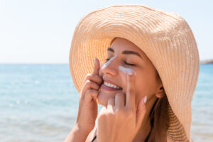 Woman applying sunscreen to protect skin in the summer from sun damage